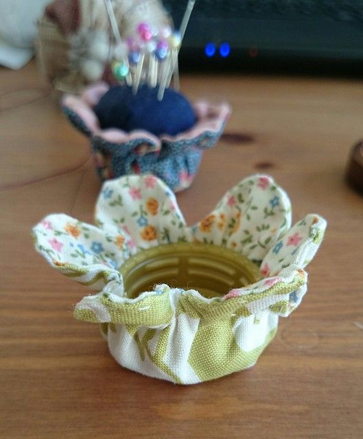 three small fabric flower vases sitting on top of a wooden table