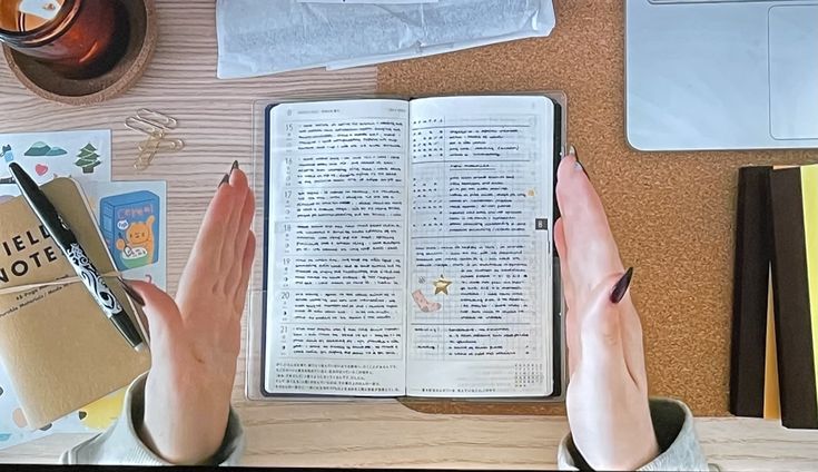 a person sitting at a desk with an open book