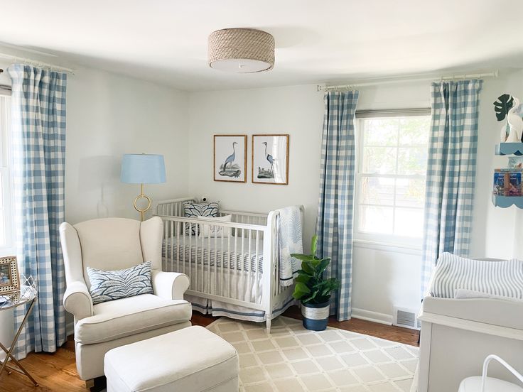 a baby's room is decorated in white and blue colors with plaid drapes on the windows