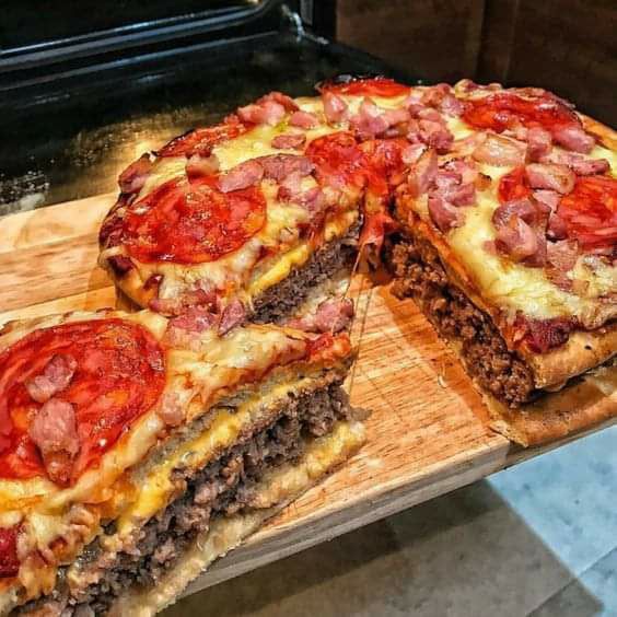 there is a large pizza cut in half on a cutting board next to an oven