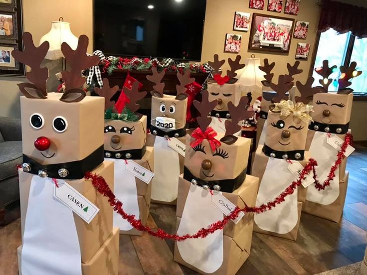 paper bag reindeers are lined up on the floor in front of a christmas tree