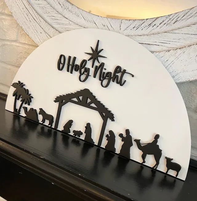 a nativity scene with the birth of jesus and baby jesus in silhouette on a mantle