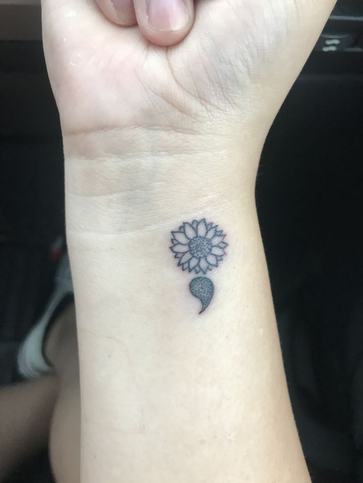 a woman's wrist tattoo with a flower on the left side of her arm