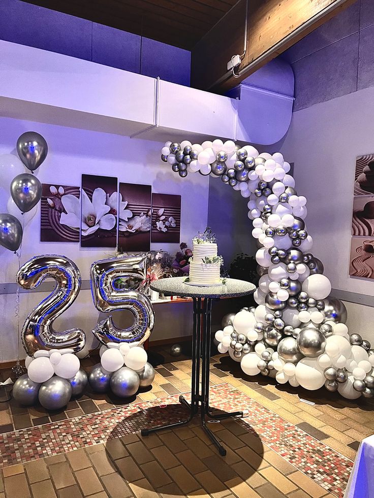 balloons are arranged in the shape of numbers on a table with a cake and other decorations