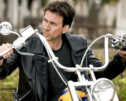 an autographed photo of a man on a motorcycle with his hand on the handlebars