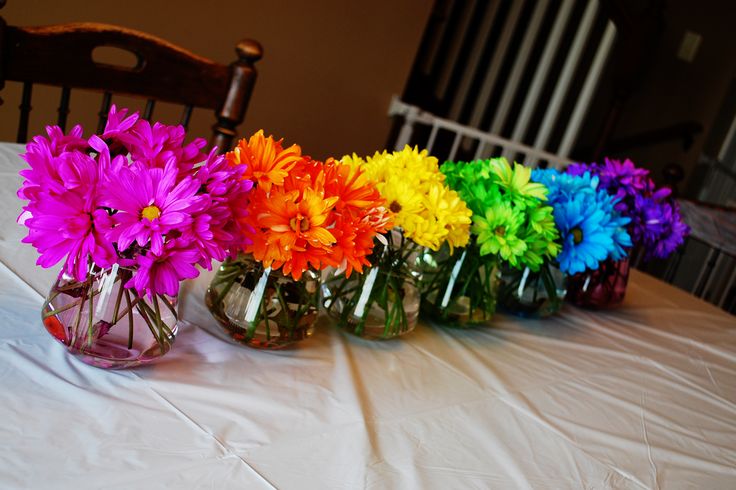 several vases filled with colorful flowers on top of a white tablecloth covered table