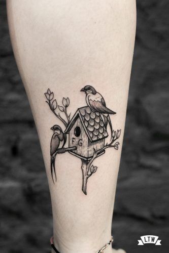 a small bird house tattoo on the leg