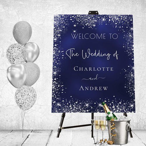 a welcome sign with champagne and balloons in front of it on a easel against a white wall