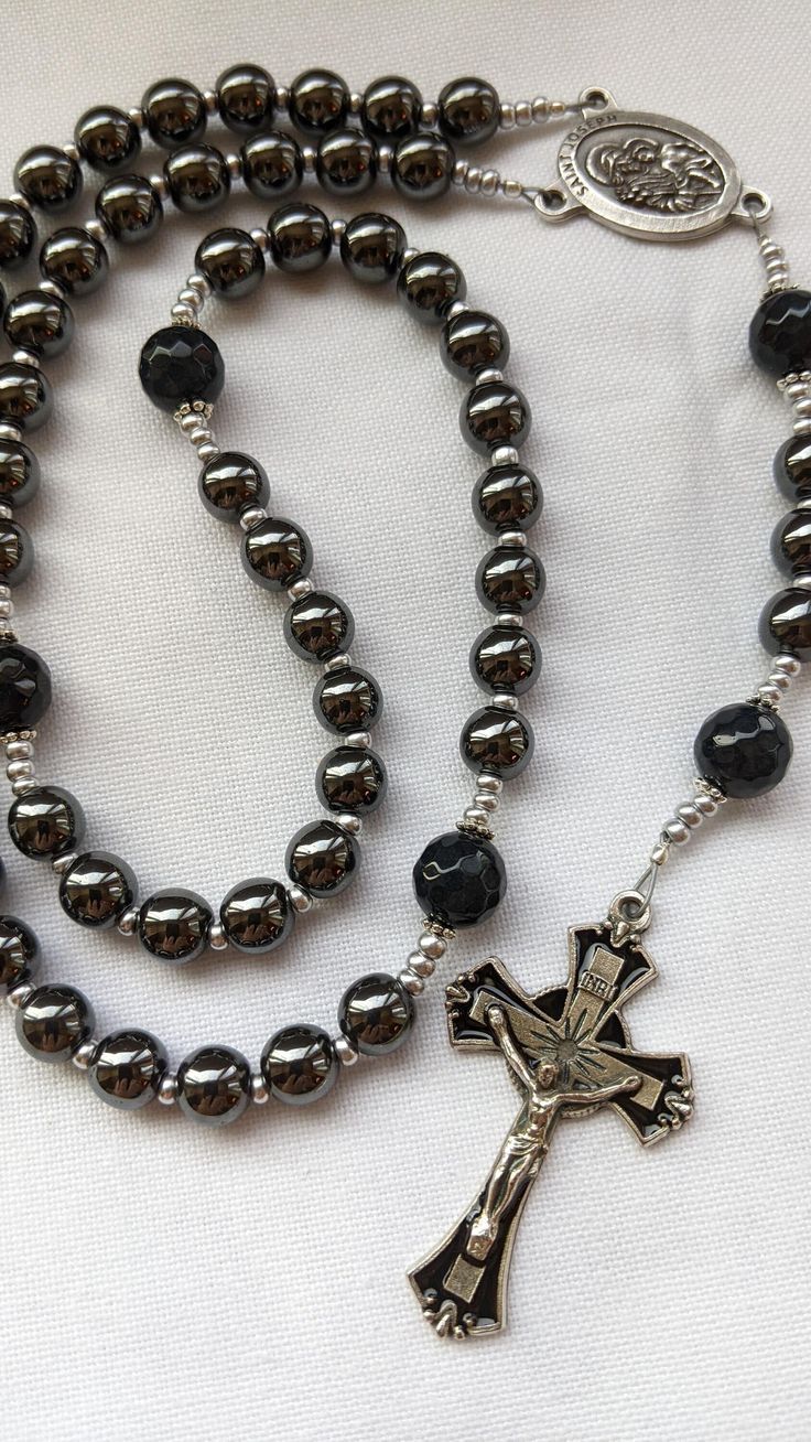 This is a beautiful, handcrafted men's rosary thoughtfully designed with a St. Joseph centerpiece, the Patron Saint of husbands, fathers, and workers. The rosary includes a black enamel cross from Italy, plated Hematite Beads, and Lava Stones. The rich dark colors make it a gorgeous, yet masculine piece. It is heavy weight and would make a wonderful gift! Perfect for wedding, new father, Father's Day, RCIA, anniversary or any other special occasion!  - Crucifix: 1.75-inch Black Enamel Crucifix f Jesus Crucifixion Pictures, Rosary Design, Mens Rosary, New Father, Enamel Cross, Rosary Beads Catholic, New Fathers, Rosary Bracelet, The Rosary