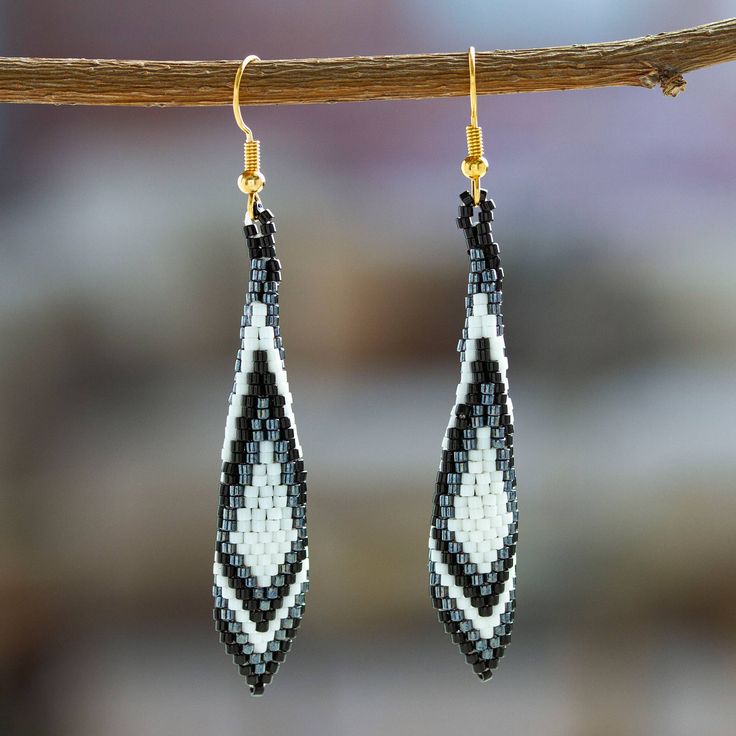 Handcrafted by artisan Angeles Gonzalez from Mexico, these gorgeous feather-shaped dangle earrings are perfect to complement any outfit. Angeles places each glass bead meticulously to form a black and white geometric pattern that embellishes these elegant earrings with 14k gold-plated hooks. Native American Beadwork Earrings, Black And White Geometric Pattern, Native Beading Patterns, Beaded Earrings Native, Brick Stitch Earrings, Buy Bead, Art Pendant, Beaded Dangle Earrings, Seed Bead Earrings