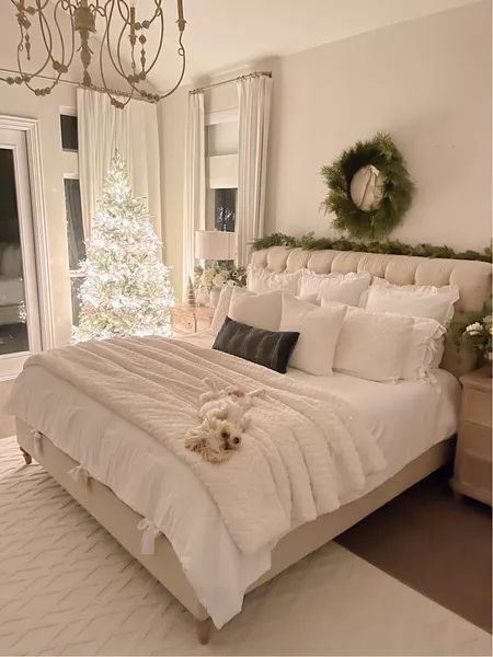 a bedroom with a white bed and christmas decorations