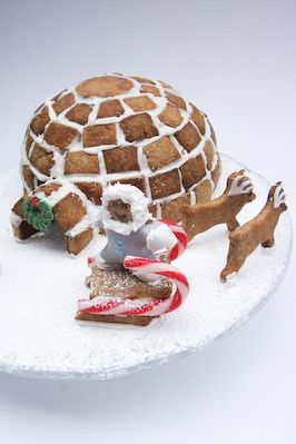 an igloose cake is decorated with gingerbreads and other holiday treats