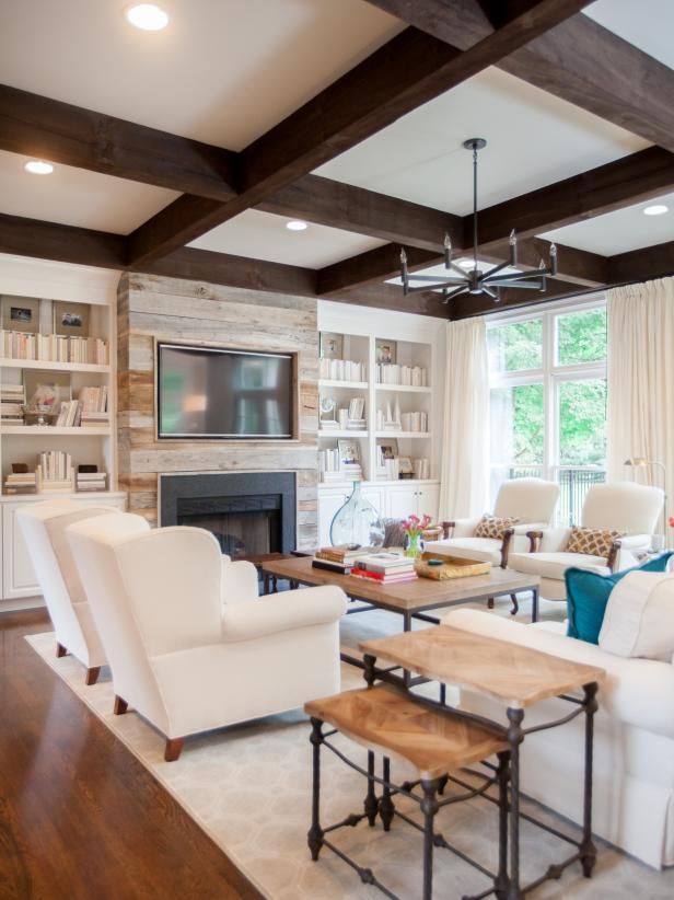 a living room filled with furniture and a flat screen tv mounted on the wall above a fireplace