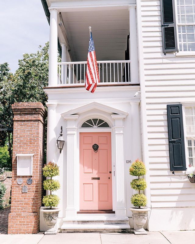 an american flag hangs on the front door of a white house