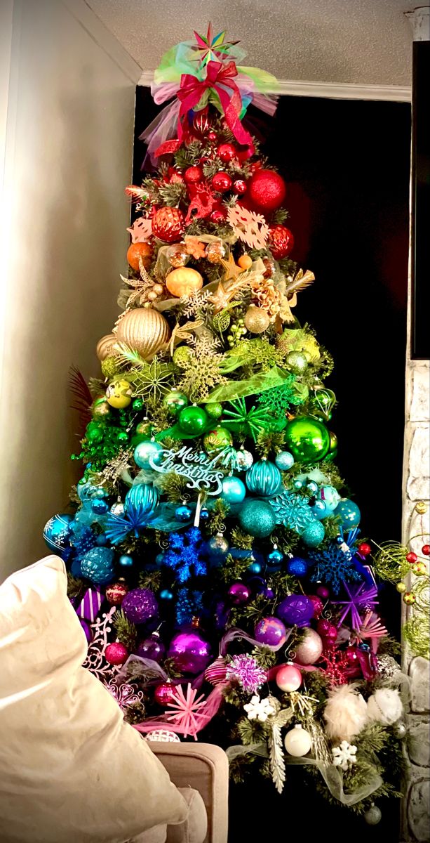 a very colorful christmas tree with ornaments on it