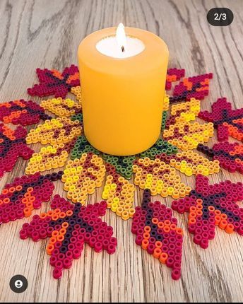 a candle sitting on top of a wooden table next to a flower shaped doily