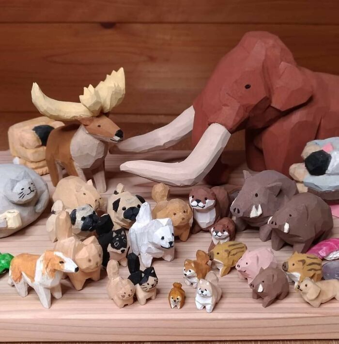 various animal figurines are displayed on a wooden surface, including an elephant and other animals