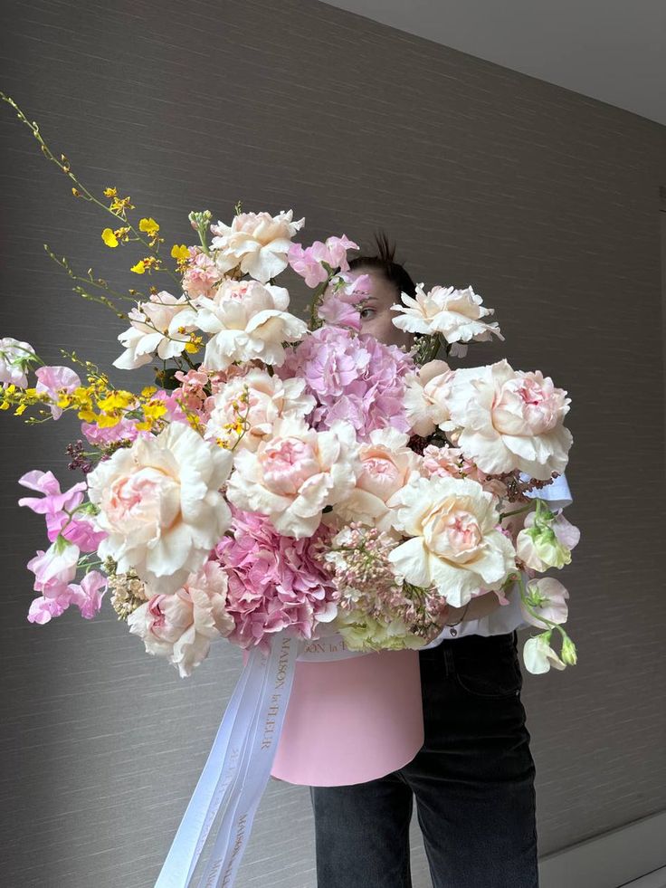 a woman holding a large bouquet of flowers