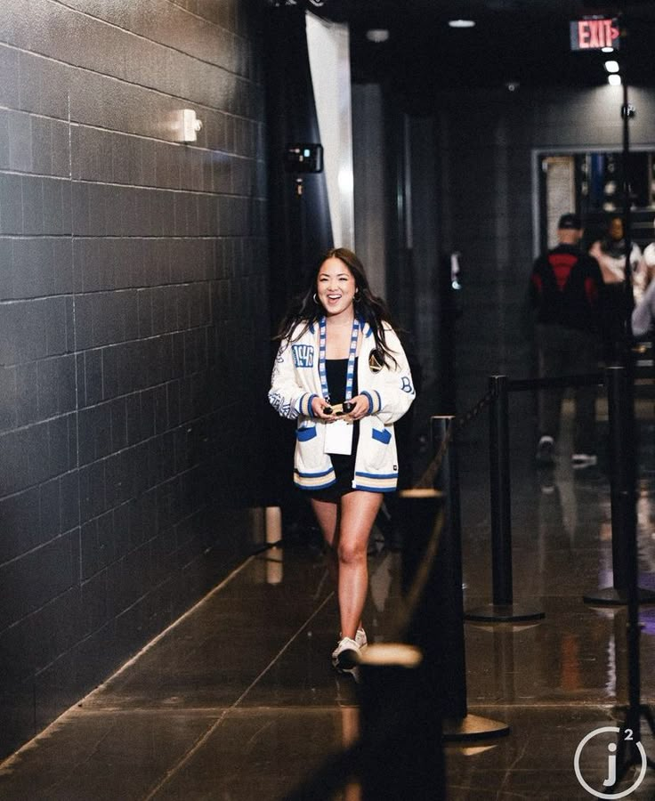 a woman is walking down the hallway with her skateboard