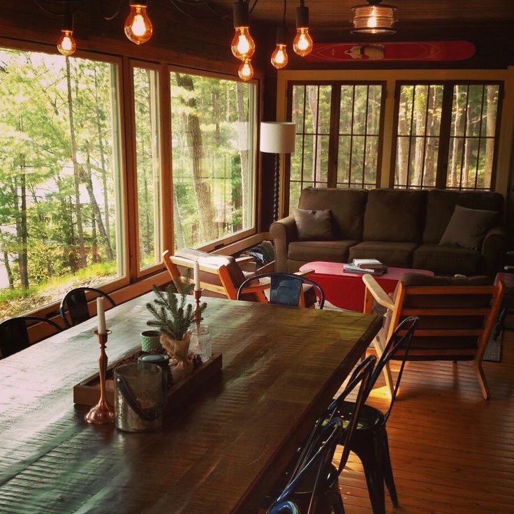 a living room filled with lots of furniture next to a wooden table covered in plants