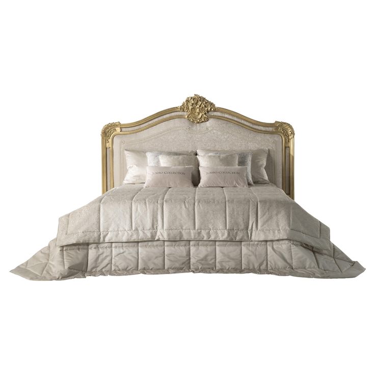 a white bed with gold trim and pillows on it's headboard, in front of a white background