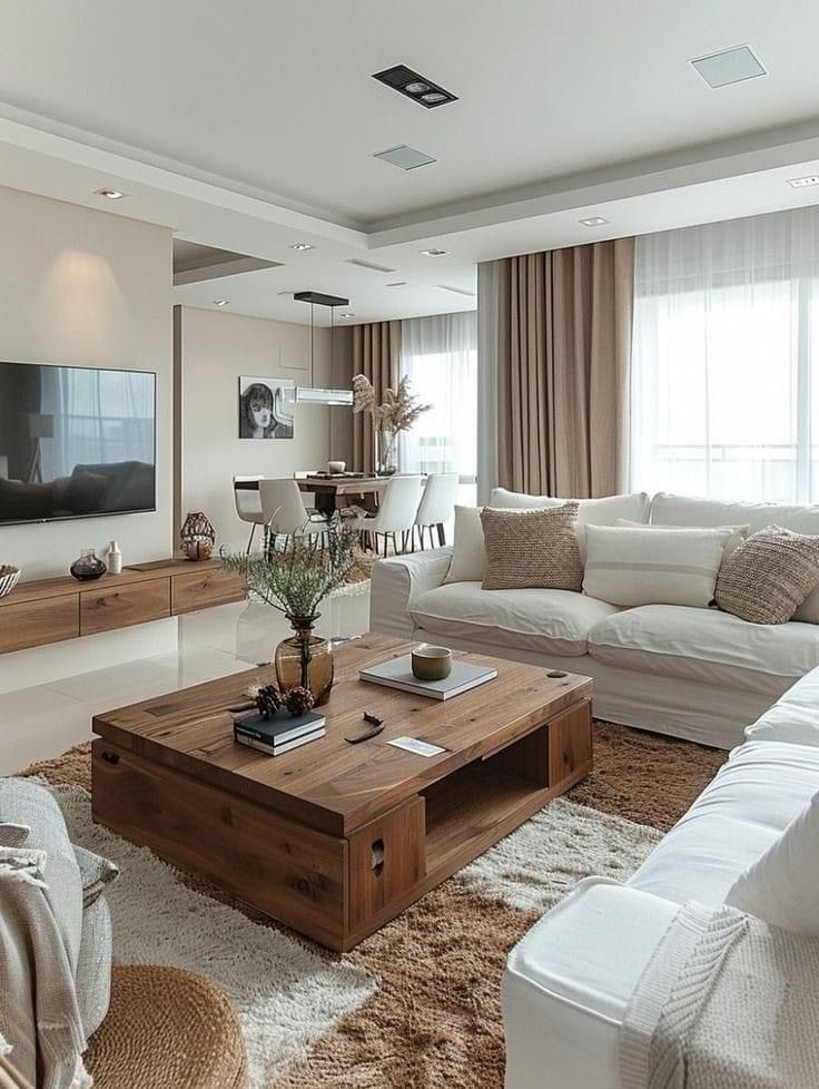 a living room filled with furniture and a flat screen tv mounted on the wall above it