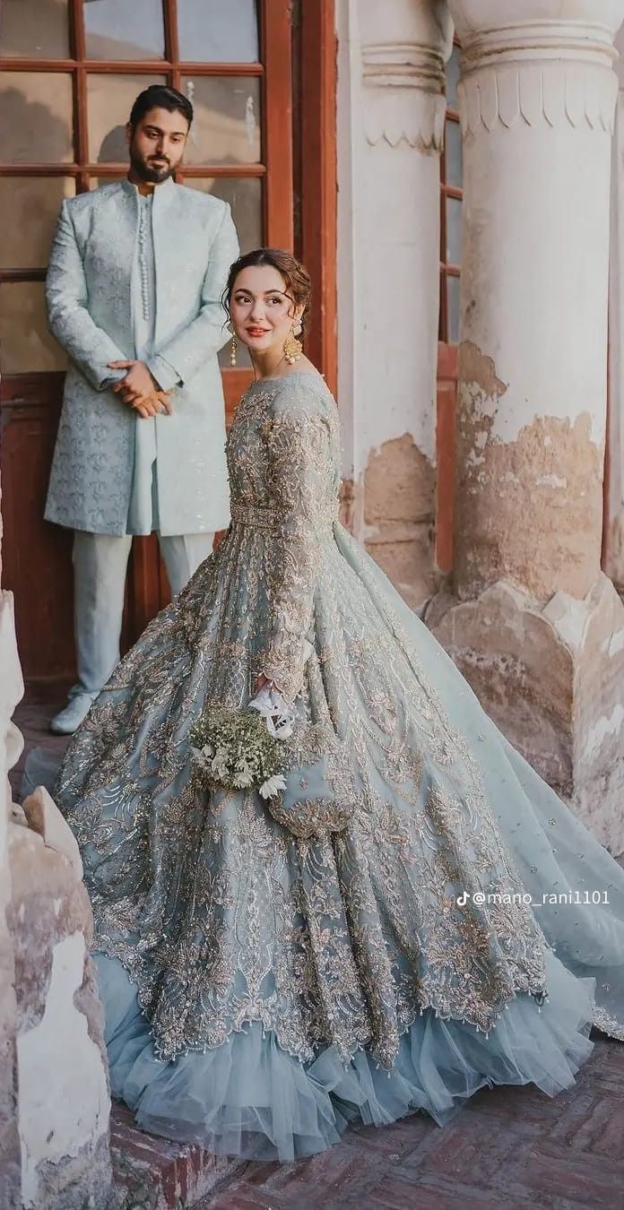 a man standing next to a woman in a wedding dress