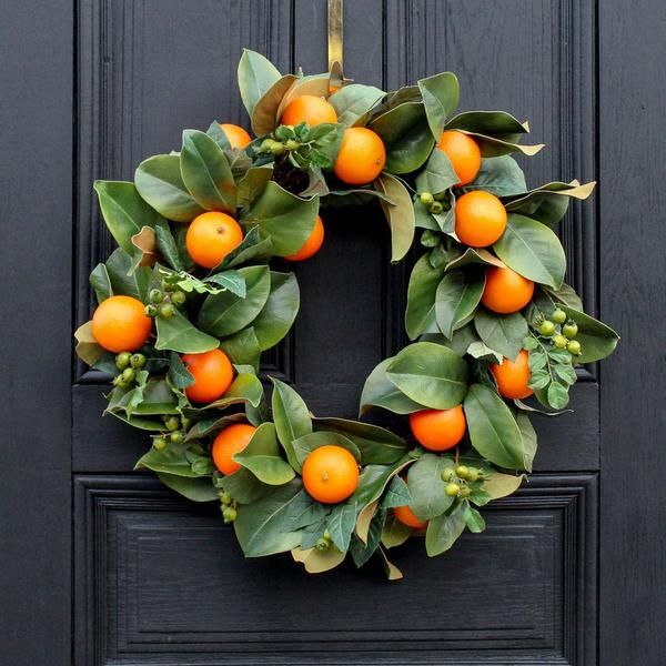 an orange wreath is hanging on the front door