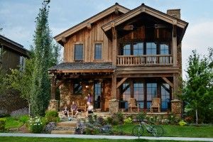 a large wooden house sitting on top of a lush green field