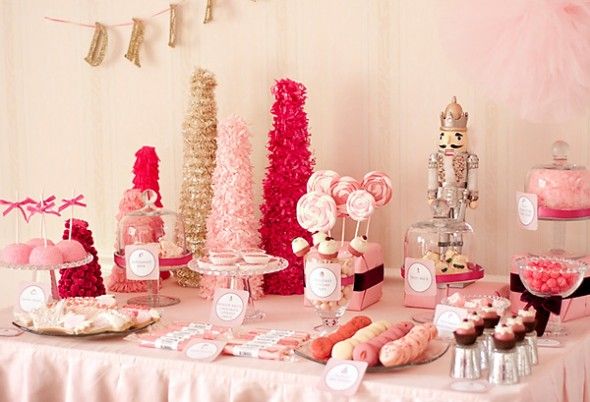 a table topped with lots of pink and white desserts on top of a table