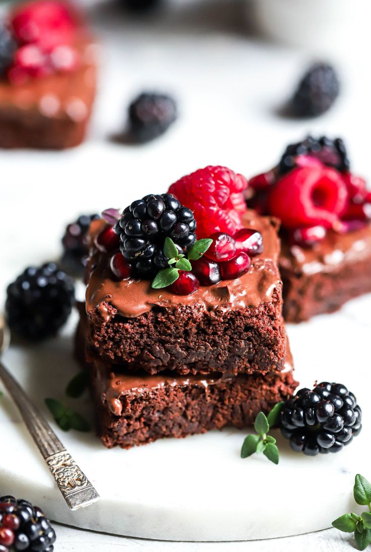 two pieces of chocolate cake on a plate with berries