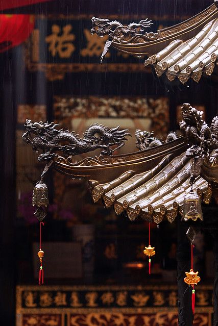 two metal dragon ornaments hanging from the ceiling