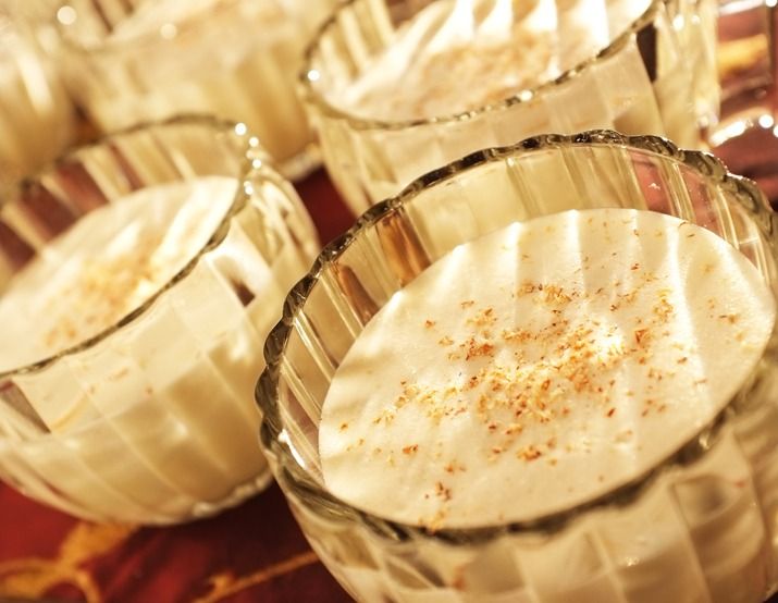 several glasses filled with desserts on top of a table