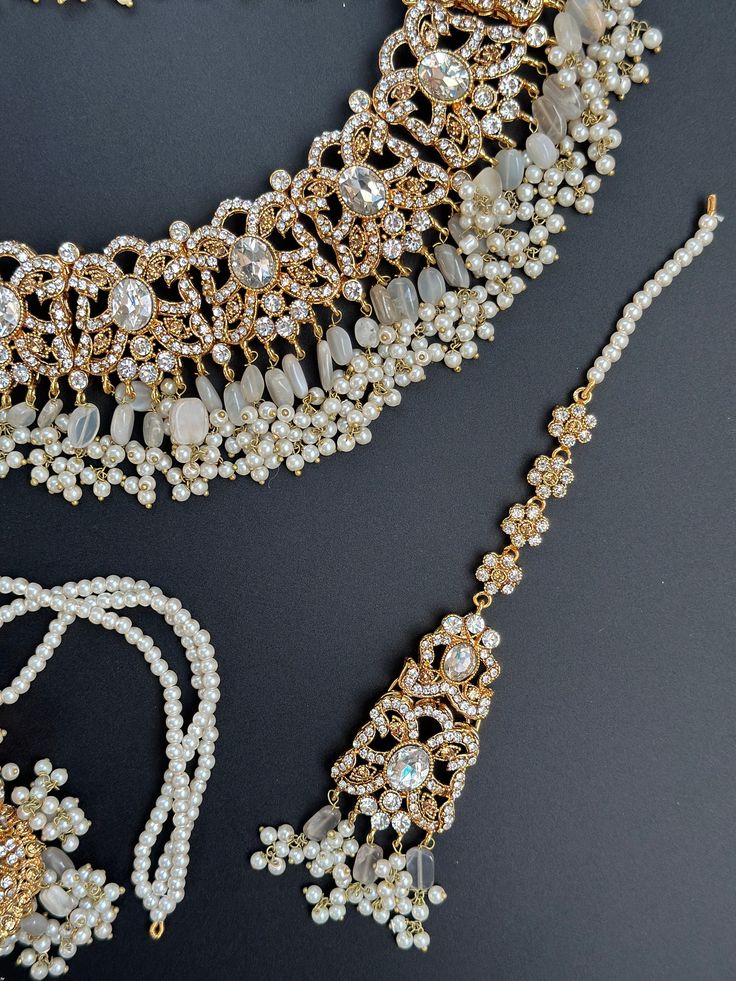 Discover the epitome of elegance with our Polki Choker Set, a celebration of exquisite craftsmanship and timeless allure. This set is a fusion of cultural beauty, featuring not one, but two necklaces, a stunning tikka, and a pair of earrings, all adorned with delicate polki and intricate kundan work. Pastel Perfection and Subtle Gray/Dusty Blue Envelop yourself in the soft embrace of pastel hues and graceful gray/dusty blue accents. The choker set boasts a delicate balance of colors, reflecting Elegant Hand Set Tikka For Festive Occasions, Festive Jewelry With Stone Work For Celebration, Elegant Meenakari Tikka For Festivals, Elegant Cutdana Tikka For Festivals, Fusion Style Kundan Necklace For Party With Intricate Design, Elegant Kundan Necklace For Eid Celebration, Fusion Style Festive Jewelry Sets With Elegant Design, Fusion Style Bridal Necklace With Tilla For Party, Elegant Cutdana Jewelry Sets For Eid