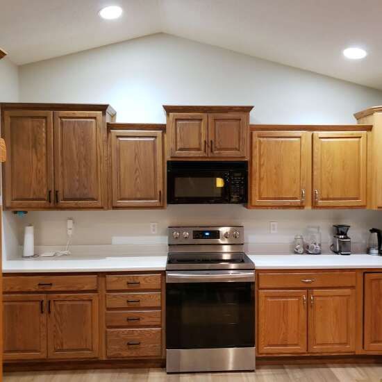 a kitchen with wooden cabinets and stainless steel appliances