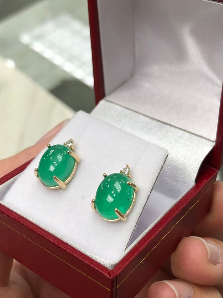 Featured here is a magnificent set of 8.50 total carat weight, cabochon-cut emerald & diamond studs in fine 14K yellow gold. Displayed are medium-green emeralds with very good transparency, accented by brilliant round diamonds in a simple four-prong gold mount, allowing for the emerald to be shown in full view. The earth mined, green emeralds have a desirable lush green color with excellent qualities. These earrings are ideal for everyday use and are the perfect accessory to any outfit. Emer Fine Jewelry Cabochon Gemstones For Formal Occasions, Formal Fine Jewelry Cabochon Gemstones, Exquisite Formal Gemstone Cabochons, Formal Fine Jewelry Gemstone Cabochons, Yellow Gold Cabochon Earrings For Anniversary, Exquisite Cabochon Earrings For Formal Occasions, Elegant White Gold Cabochons As Gift, Exquisite Formal Cabochon Earrings, Fine Jewelry Green Cabochons For Formal Occasions