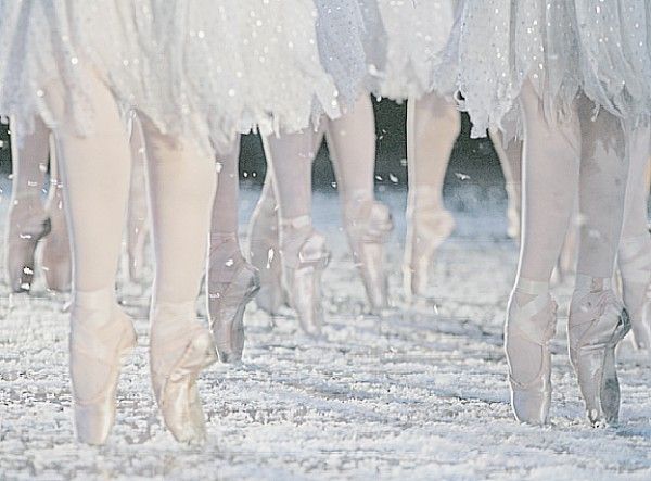 several ballerinas are walking in the snow with their feet covered by snowflakes