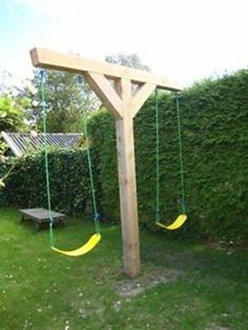 an image of a wooden swing set in the yard