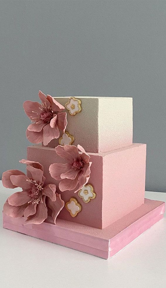 a three tiered cake with pink flowers on top