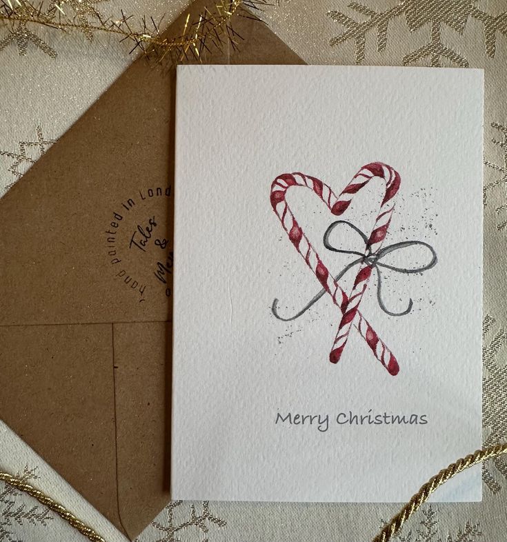 a christmas card with a candy cane in the shape of a heart on top of it