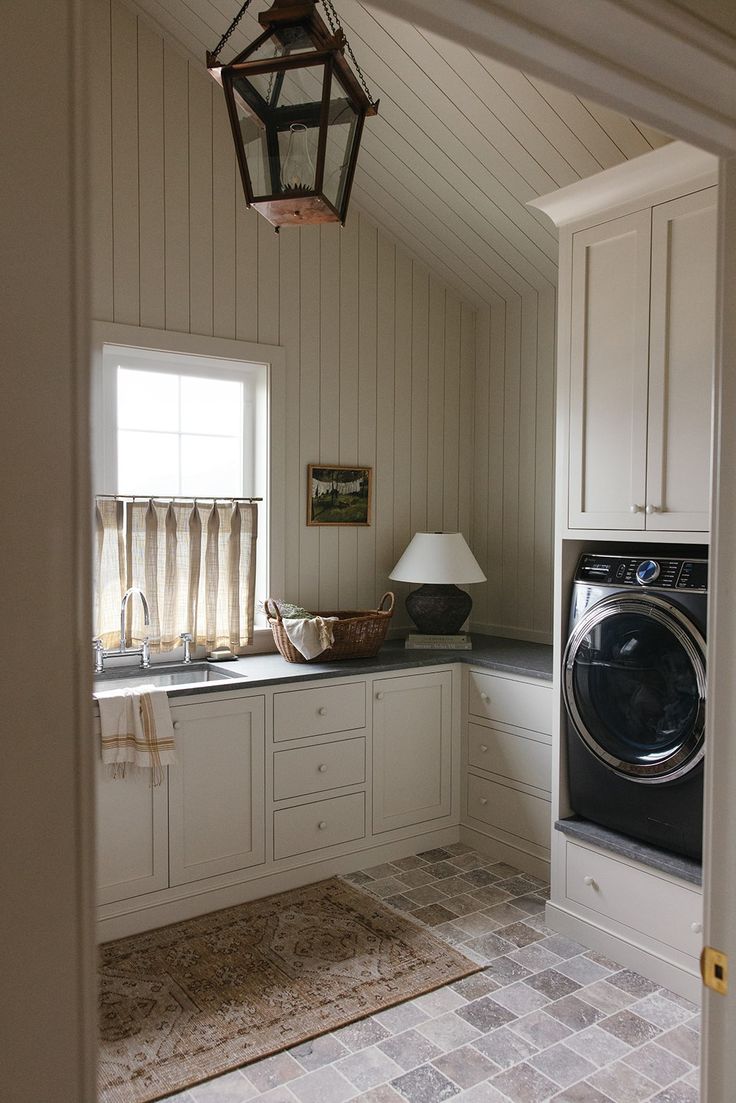 a washer and dryer are in the corner of a room with white walls