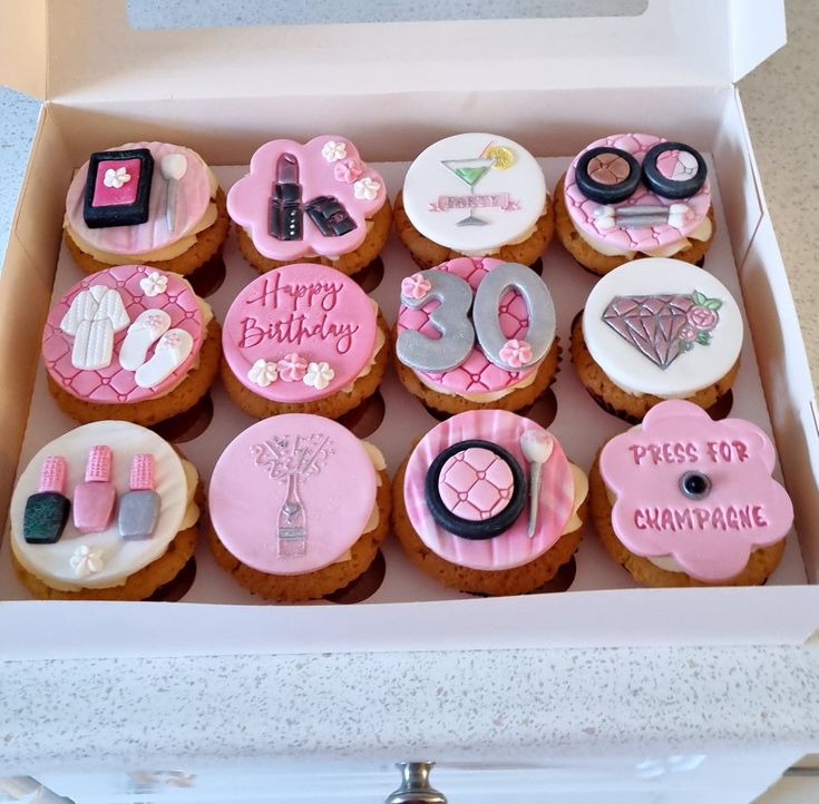 a box filled with lots of decorated cupcakes