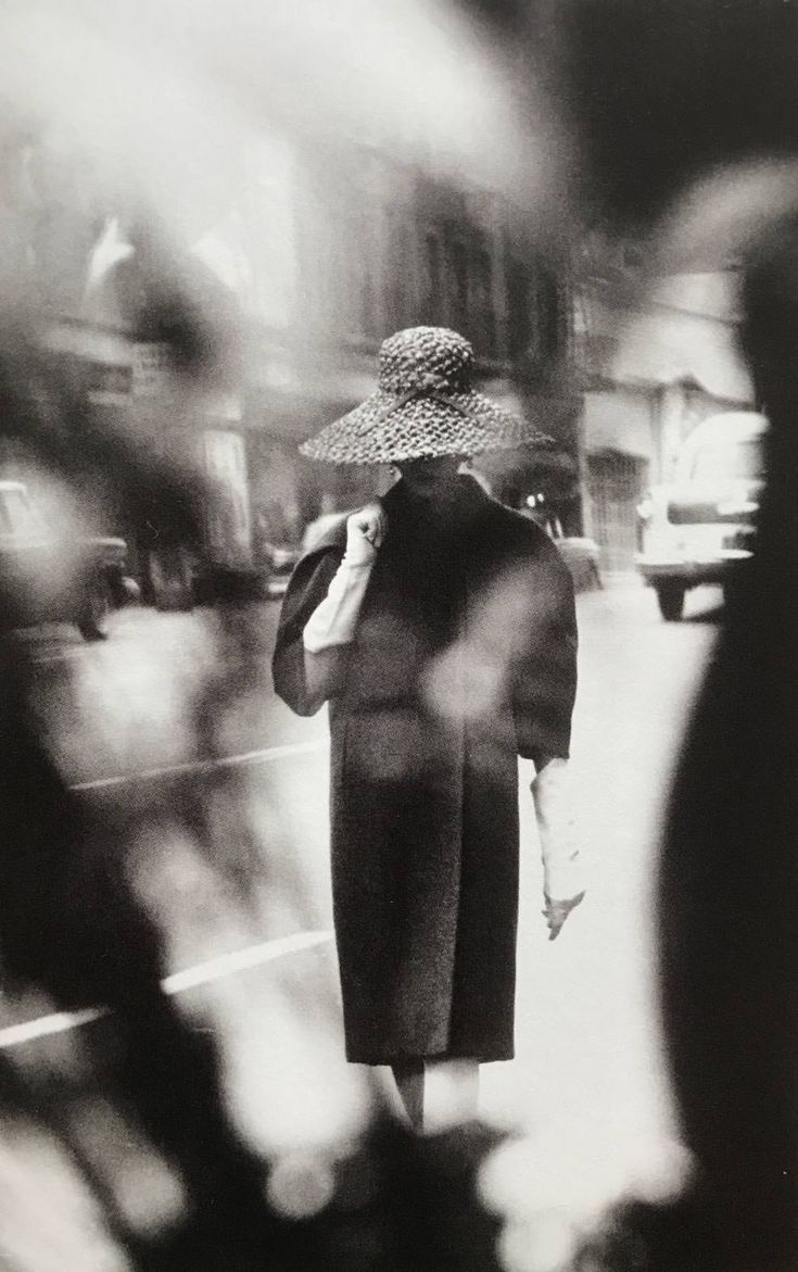 black and white photograph of woman walking down the street