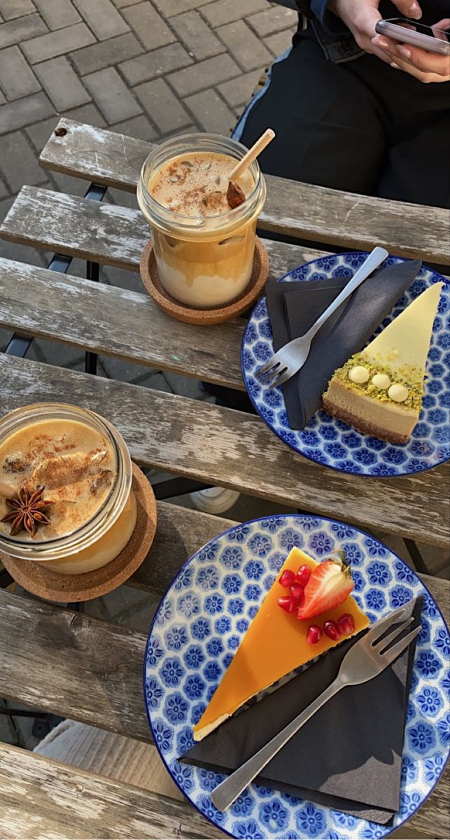 two plates with desserts on them sitting on a wooden bench next to each other