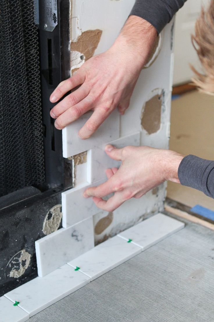 two hands reaching for something in front of a wall that has been built into it