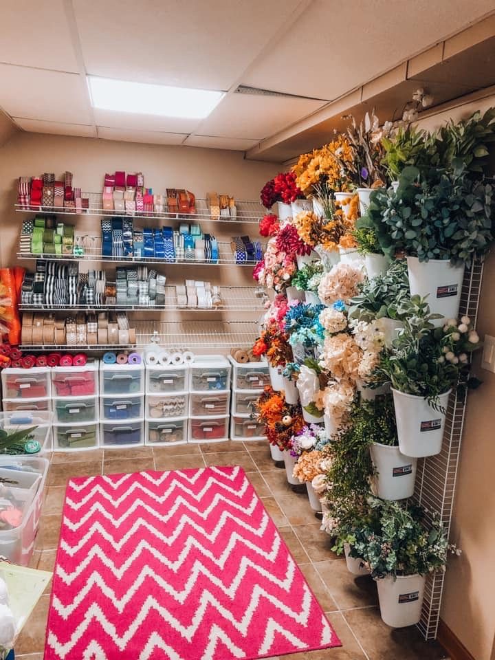 a flower shop filled with lots of different types of flowers and plants on shelves next to each other