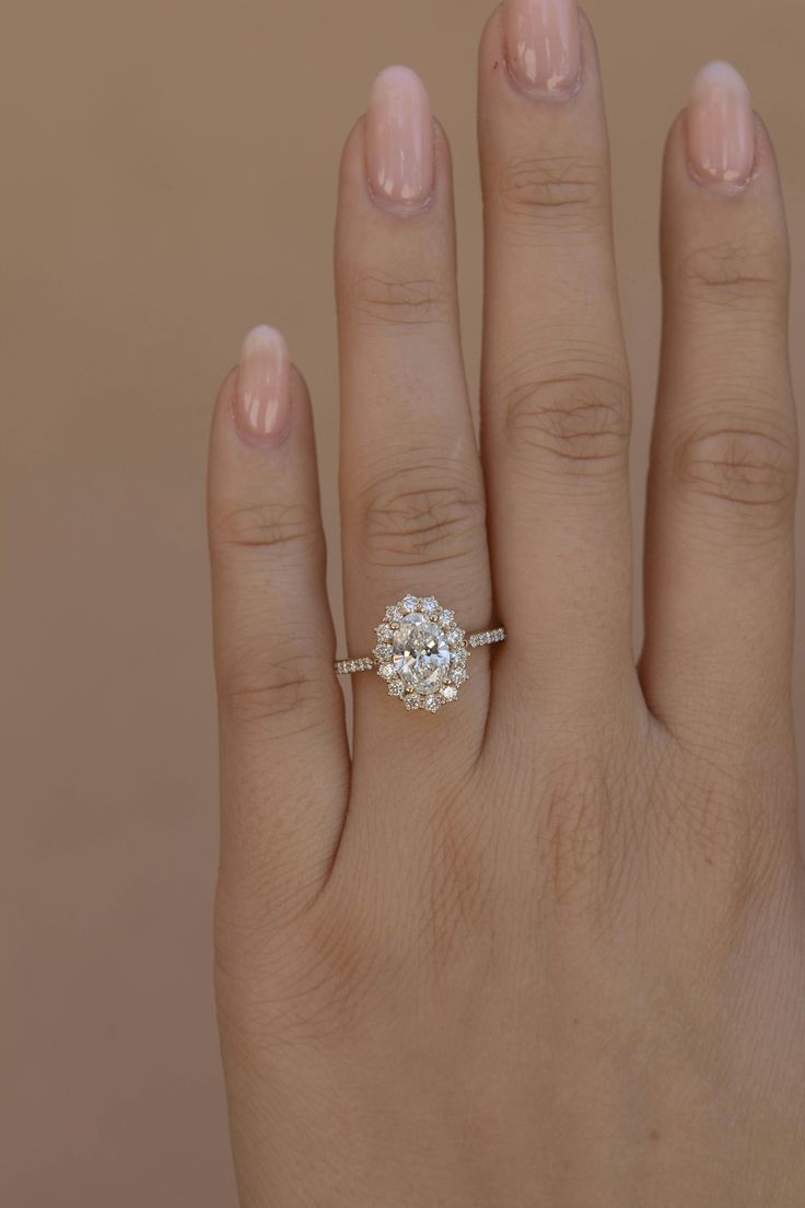 a woman's hand with a diamond ring on top of her left hand,