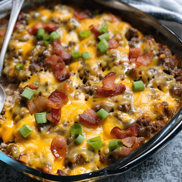 a casserole dish with meat, cheese and green onions