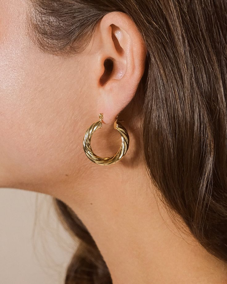 If you love bold, bright metallics and statement jewelry, you'll want to wear these twisted hollow hoops every day! We added a textured twist to the classic hoop earring to create something unique and bold. Materials: 14K gold or rhodium plated brass Features: 1" hoop, Lead & Nickel free, friction latch Modern Twist Gold-plated Hoop Earrings, Modern Twist Gold Plated Hoop Earrings, Gold Plated Hoop Earrings With A Modern Twist, Modern Twist Metal Twisted Hoop Earrings, Modern Twist Metal Hoop Earrings, Modern Twisted Metal Hoop Earrings, Textured Gold-plated Hoop Earrings, Textured Gold Plated Hoop Earrings, Create Something