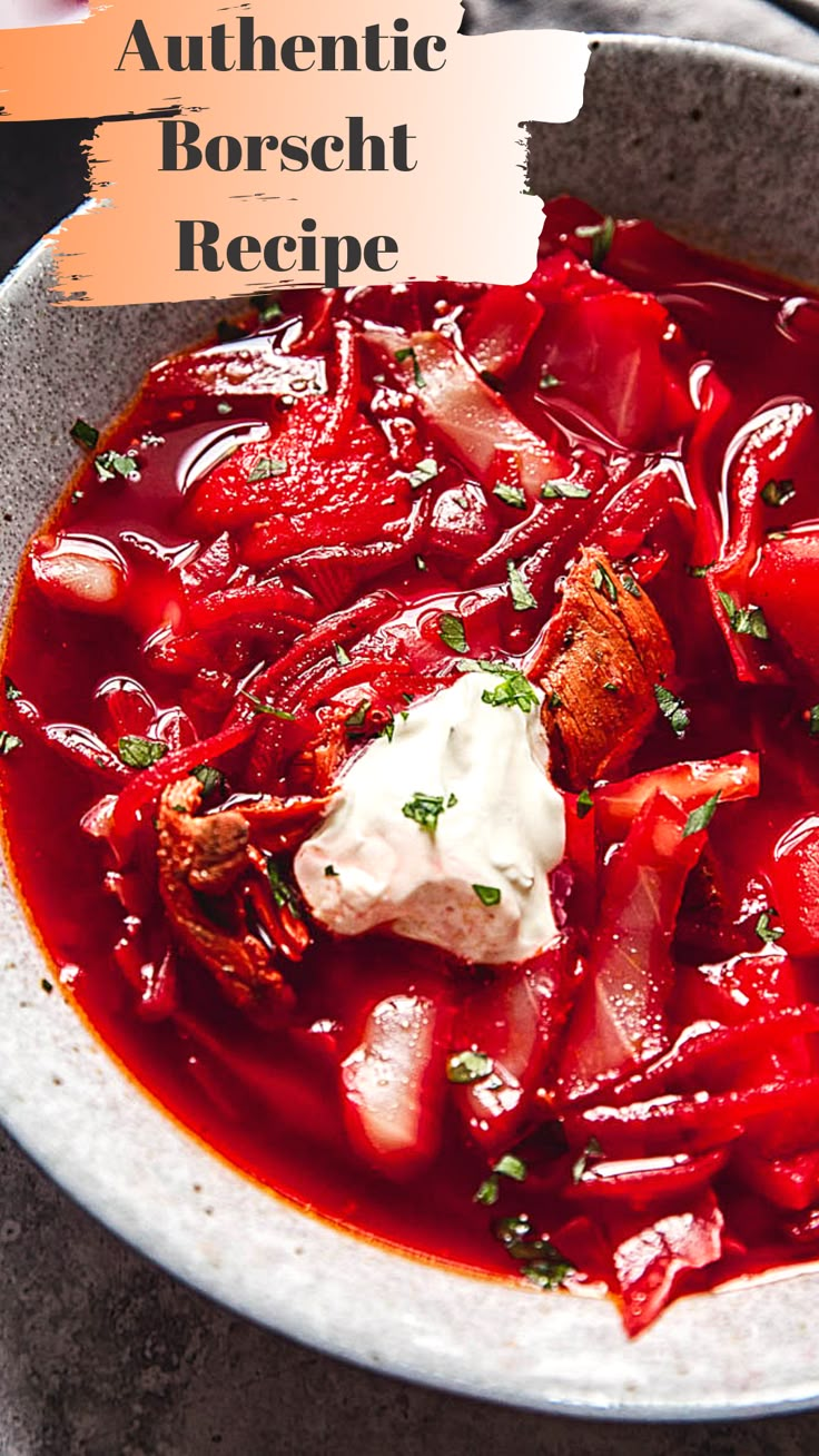 a white bowl filled with red food and garnished with sour cream on top